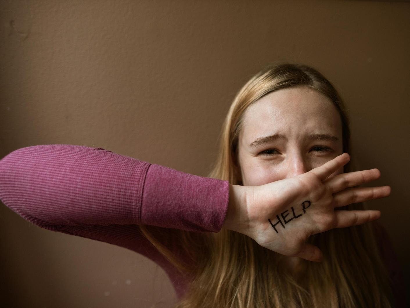 Help written on a distressed woman's palm